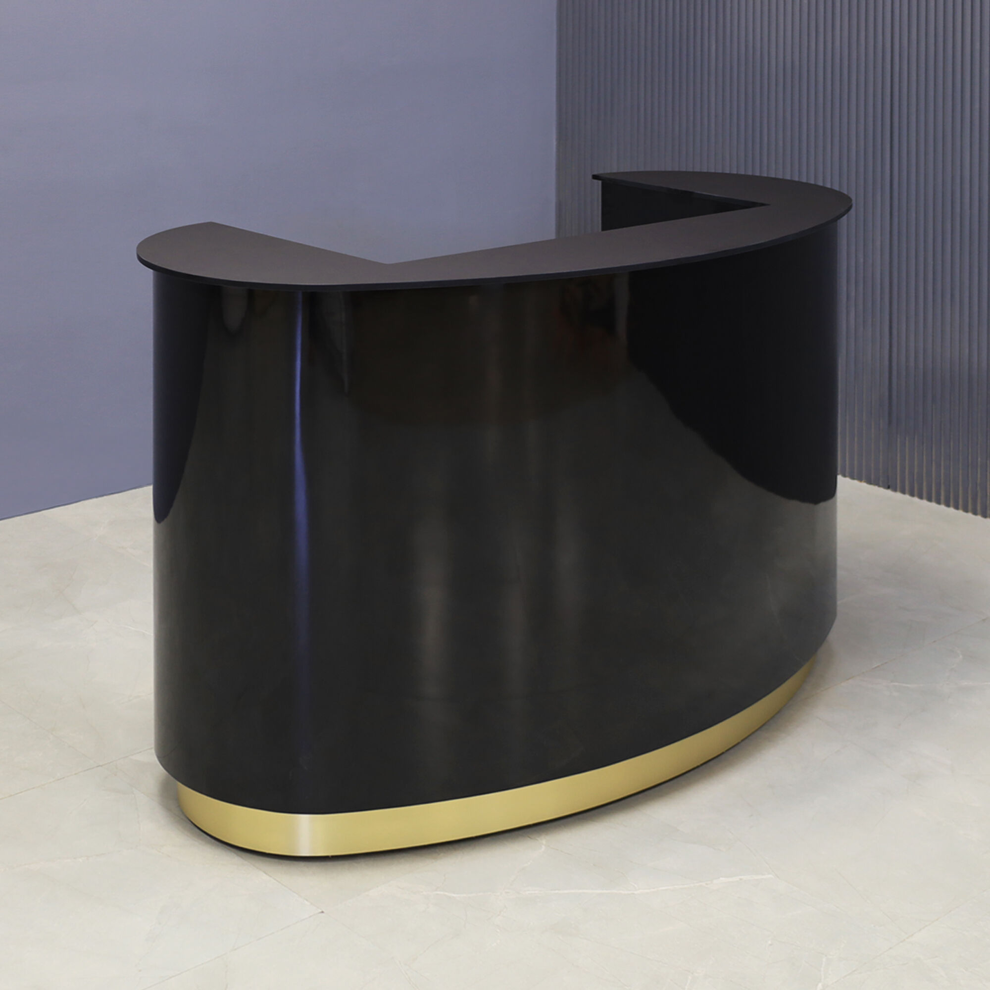 60-inch The Pill Custom Reception Desk with 1/2" black traceless engineered surface top, black gloss laminate main desk, and brushed gold toe-kick, shown here.
