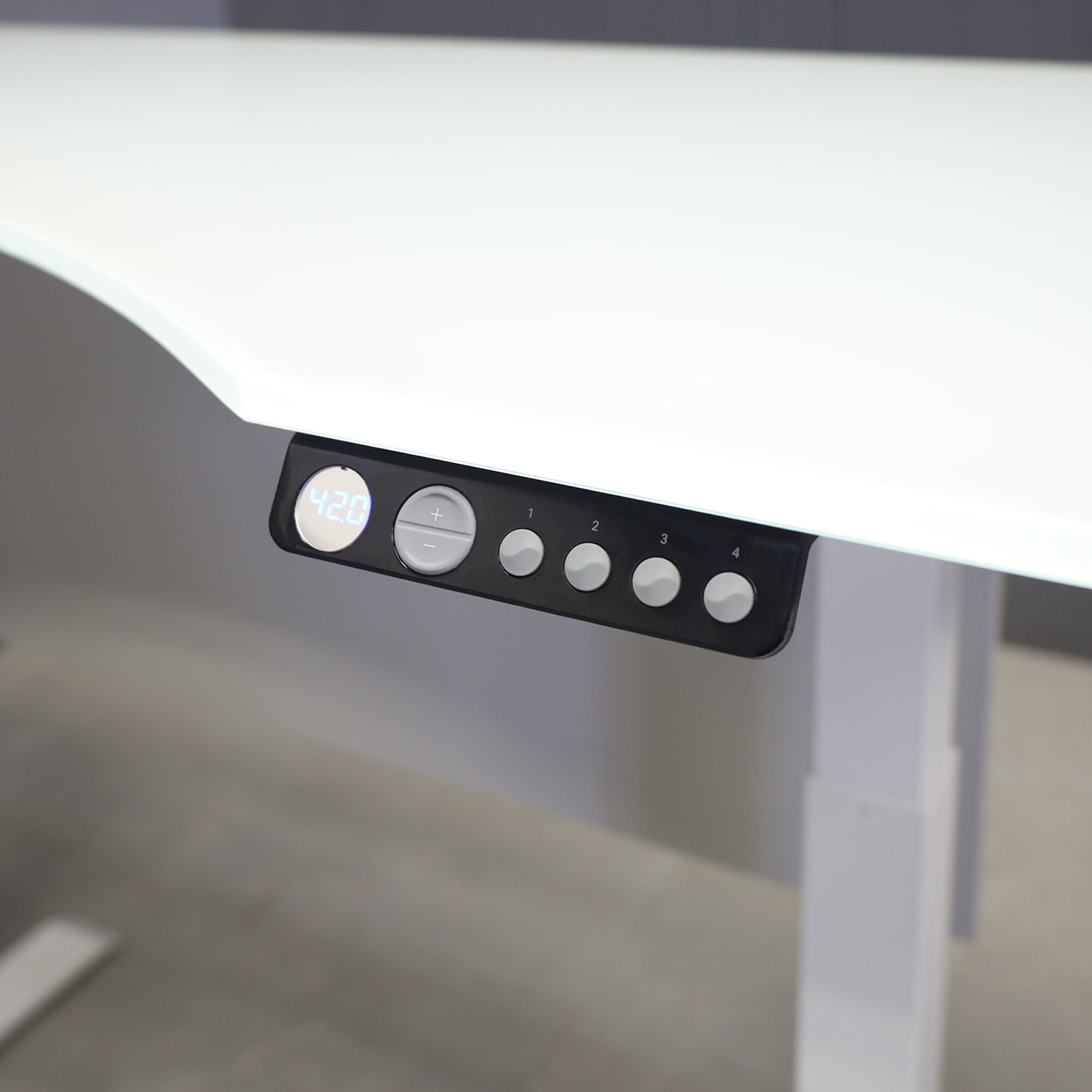 60-inch aXis Sit-stand Executive Desk with 1/2" white tempered glass top, folkstone gray matte laminate privacy panel and white metal legs, shown here.