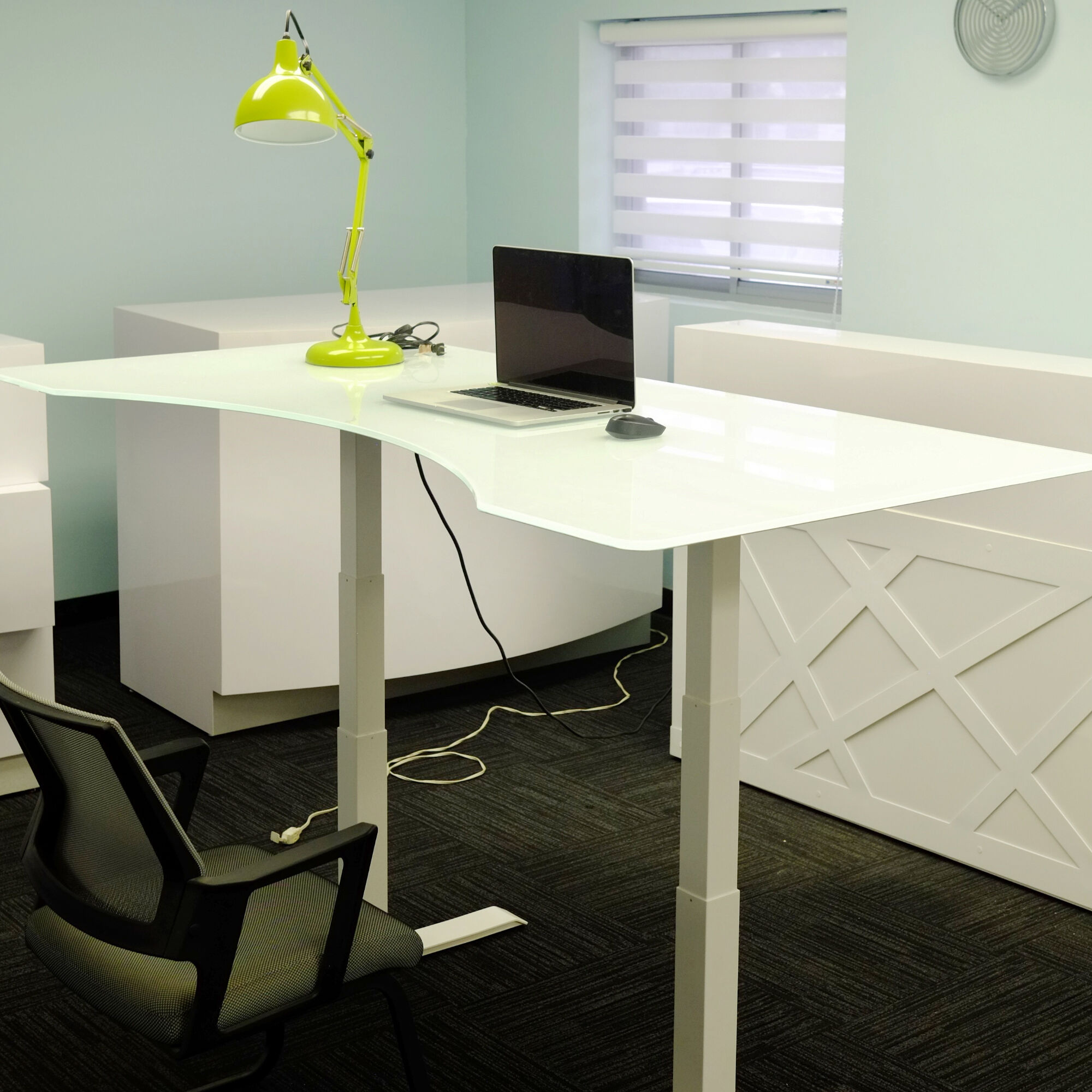 60-inch aXis Sit-stand Executive Desk with 1/2" white tempered glass top and white metal legs, shown here.